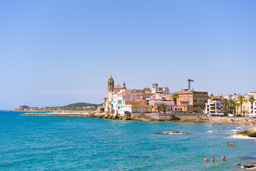 SITGES, CATALUNYA, SPAIN - JUNE 20, 2017: View of the historical center and the &ntilde;hurch of Sant Bartomeu and Santa Tecla. Copy space for text. Isolated on blue background.