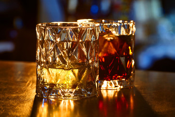 Two glasses of whiskey and ice.