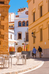 SITGES, CATALUNYA, SPAIN - JUNE 20, 2017: Two men walk through the historic part of the city. Copy space for text. Vertical.