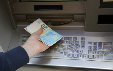atm machine and european banknotes on the hand
