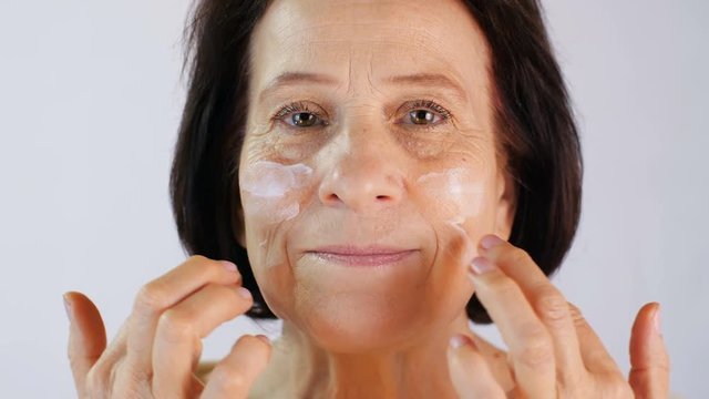 Adult woman applying cream
