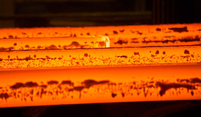 Hot metal, red on a dark background. Manufacture. Steel production close up