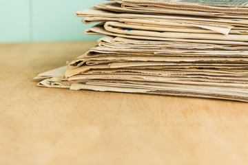 Stack of newspapers on the office wooden table. Copy space. Mockup for design.