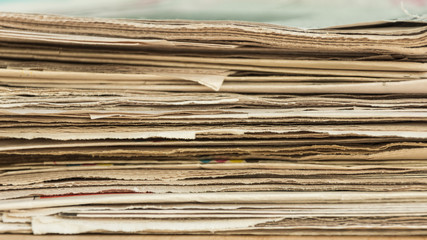 Stack of newspapers on the office wooden table. Copy space. Mockup for design.