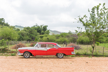 CUBA, HAVANA - MAY 5, 2017: American red retro car in the countryside. Copy space for text.