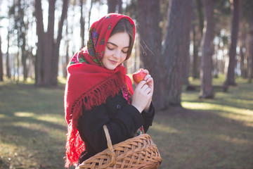 girl in red coat is walking with basket in spring forest