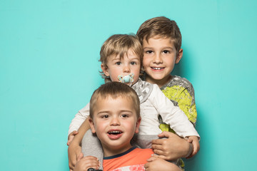 Three smiling children hugging each other