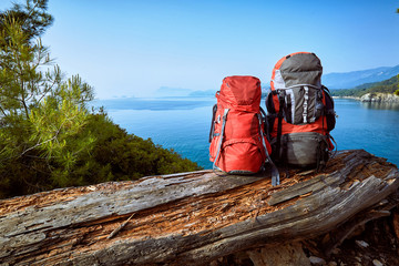 Hike with backpacks along the Mediterranean Sea in summer.