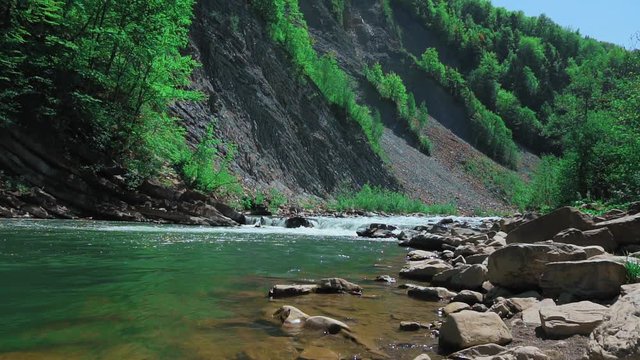 Raging Mountain river. Wildness of clean, clear water in the mountain river. Slow Motion. far shot.