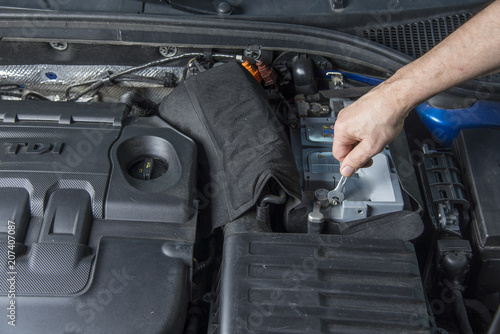 Repairman With Wrench Checking Car Battery Contacts Stock Photo And Repairman With Wrench Checking Car Battery Contacts