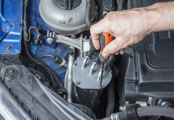 Repairman starts to change fuel filter in the car