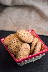 Savory cookies sprinkled with sesame seeds, sunflower on table and burlap background