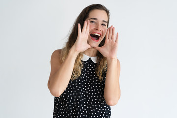 Positive pretty woman cupping hands around mouth and shouting loud. Announcement concept. Isolated front view on white background.
