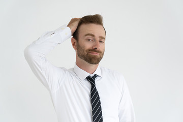 Grinning conceited businessman self satisfied. Young man in tie and white shirt touching hair with vain face. Vanity and ambition concept