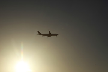 Passenger plane in the sky at sunrise or sunset. Vacation and travel concept. Toned image