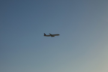 Passenger plane in the sky at sunrise or sunset. Vacation and travel concept. Toned image