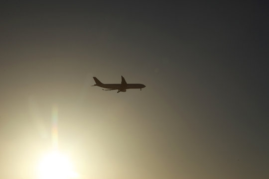 Passenger plane in the sky at sunrise or sunset. Vacation and travel concept. Toned image