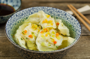Dumpling soup with soy sauce. Fresh wonton soup and soy sauce with chopsticks. 