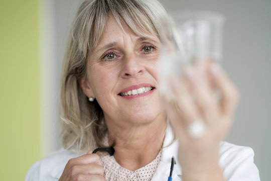 Smiling mature woman holding glass of water