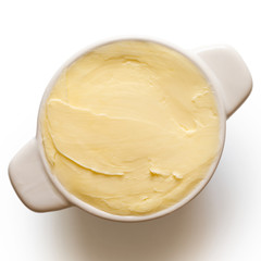 Round ceramic dish filled with butter isolated on white from above.