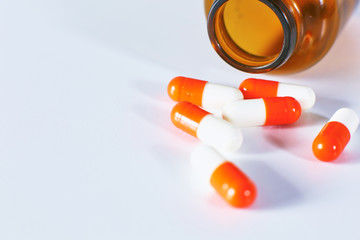 Colored pills poured from a brown bottle. Medical concept