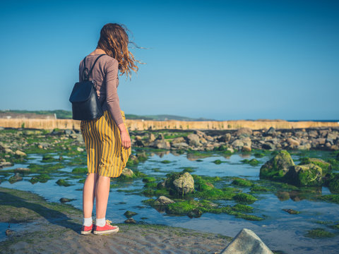 Young woman with backpack by the sea