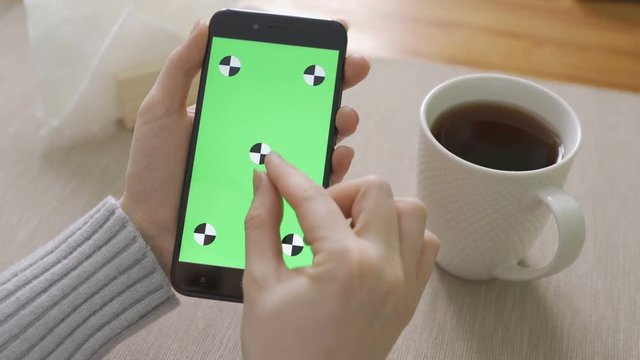 Woman Using Phone with Green Screen. Easy for tracking and keying.
