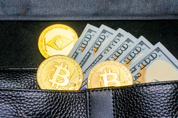 Crypto currency. Coins Bitcoin (BTC), banknotes one hundred dollars sticking out of a man's black leather purse on a wooden background.Blockchain.Intarnational currency.Top view.E-commerce.E-business.