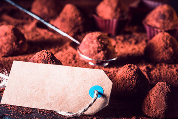 Chocolate truffles and sale tag, macro. delicious homemade truffle with dark chocolate and cocoa...