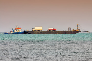 Barge on the Caribbean sea transports commercial trucks near San Pedro, Belize..