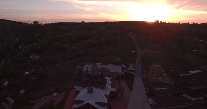 Aerial view of wooden church in small city at sunset. Christian Temple in ancient style. 4K