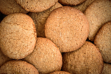 Homemade oatmeal cookies with raisins, cinnamon with milk on dark wooden background.