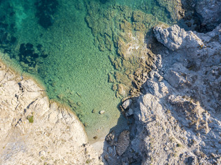 Vista aerea di scogli sul mare. Panoramica del fondo marino visto dall’alto, acqua trasparente