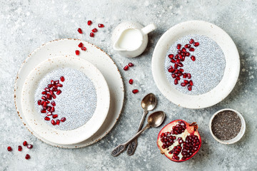Obraz na płótnie Canvas Healthy breakfast set. Chia seed pudding bowls with pomegranate.