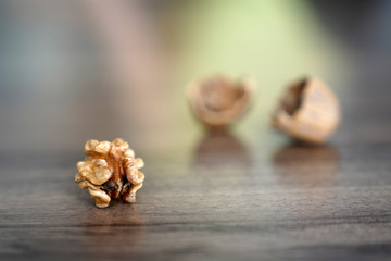 One kernel walnut with its nutshell on dark walnut table background
