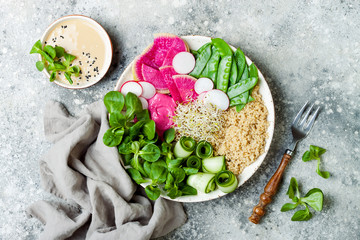 Vegan, detox Buddha bowl recipe with quinoa, snow peas, cucumber, watermelon radish, beet hummus, alfalfa seed sprouts and tahini dressing.