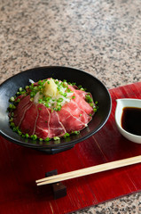 Japanese Tataki raw beef cuisine with ginger, onion, spring onion and soy sauce set on red wooden tray