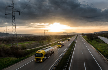 Caravan or convoy of tank trucks in line on a country highway