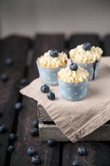 Blueberry cupcakes with cream cheese frosting, blueberries, wooden box, rustic style, summer vibes