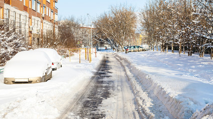 cars along road in residential district in winter