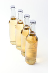 Four yellow bottles of beer on white background. 