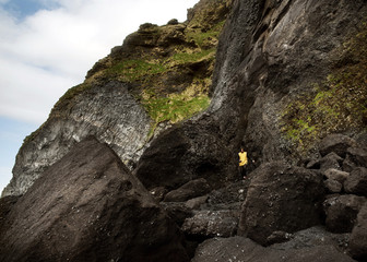 guy stands on a rock on a black beach in Iceland, the concept of freedom