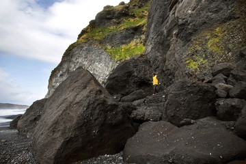 guy stands on a rock on a black beach in Iceland, the concept of freedom