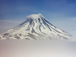 Vilyuchinsk volcano covered by snow with clouds below