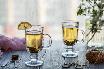 Fresh green tea. Tea cup with green tea leaf on the wooden table. Tea with lemon