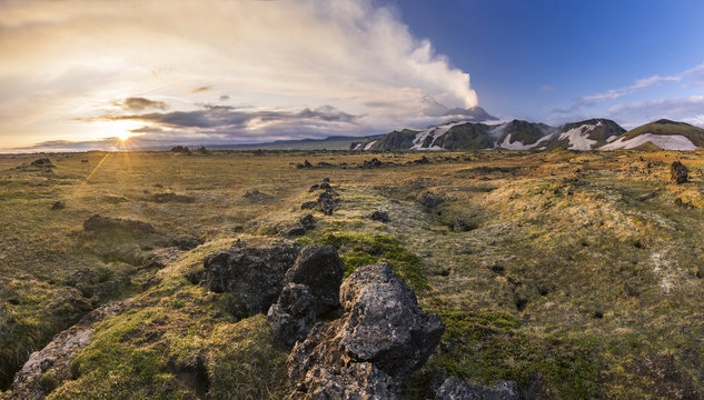 active volcanoes of Kamchatka with snowy hills at sunset