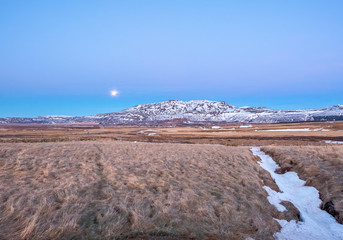 Mountain and field under full moon in Iceland
