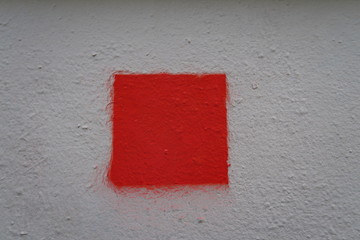 Carré rouge sur façade blanche. test de peinture