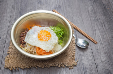 Bibimbap set serve in pot with slice dish kimchi and seaweed soup, chopstick and spoon