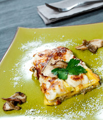 Canelloni: typical homemade stuffed and baked pasta. Dressed with mushrooms, bechamel and parmesan.